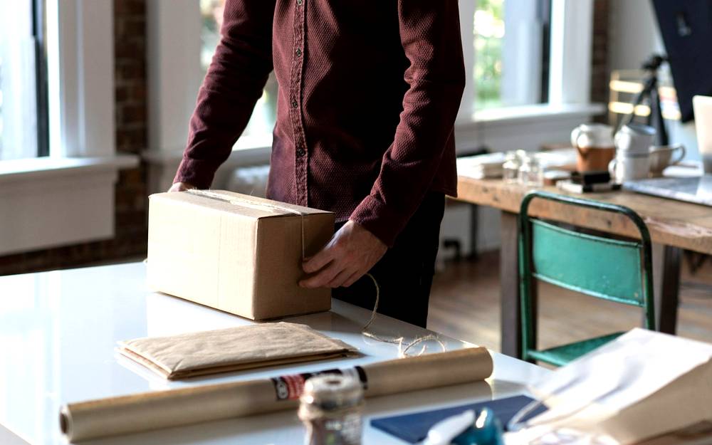 Schreibtisch mit Laptop wird für einen Büroumzug in Kartons gepackt
