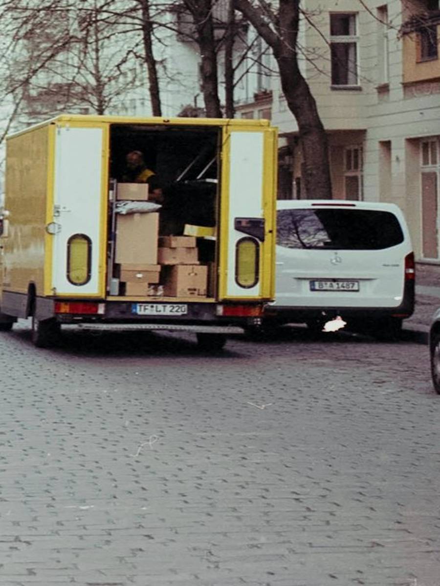 Zwei Träger heben schwere Bündel auf die Ladefläche eines Umzugswagens